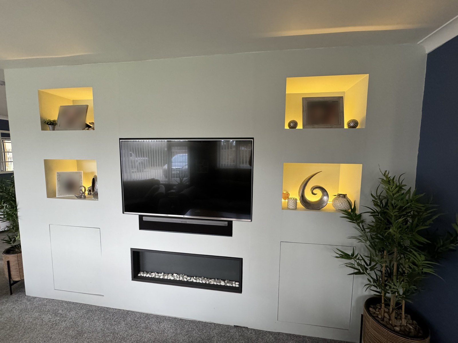 Living-room media wall with warm-lit alcoves